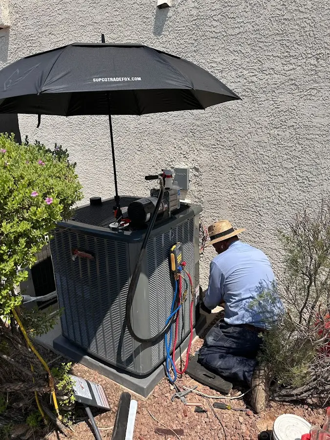 HVAC technician performing outdoor AC maintenance in Owensboro