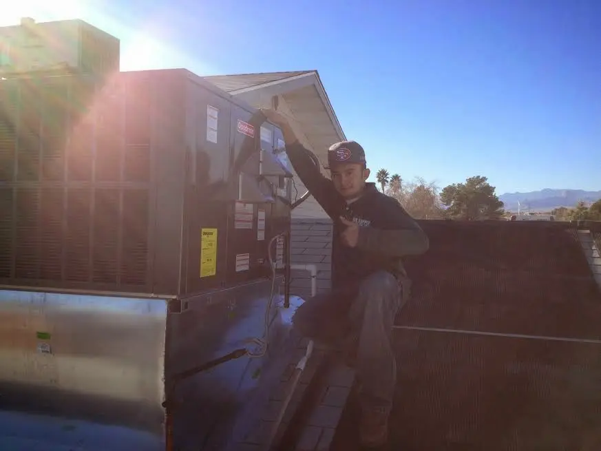 HVAC technician performing AC Tune-Up on a rooftop unit in Owensboro